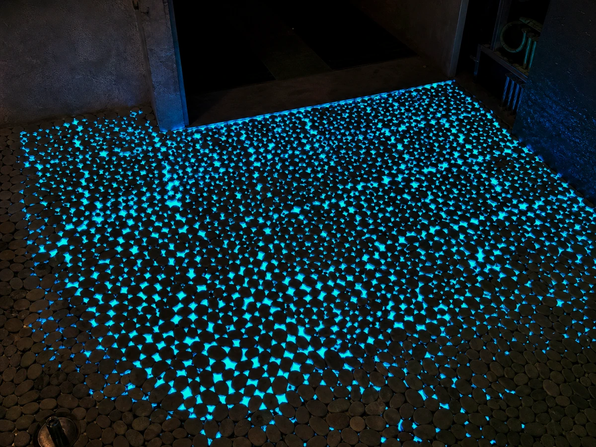 Buitenoppervlak met blauw oplichtende steentjes in het donker